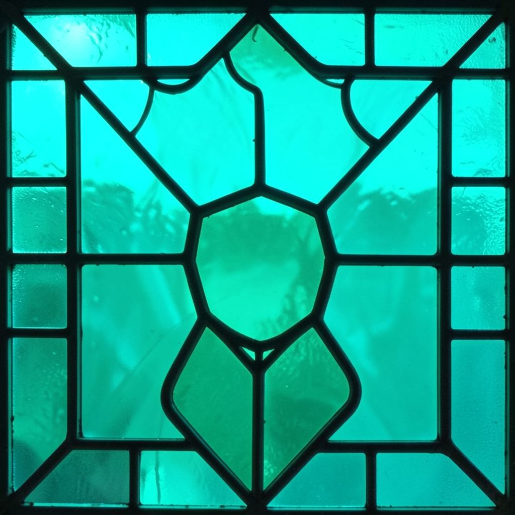 Stained-glass panel in deep blue and amber showing a smartphone-like shape connected by bold leaded lines, calm technical mood